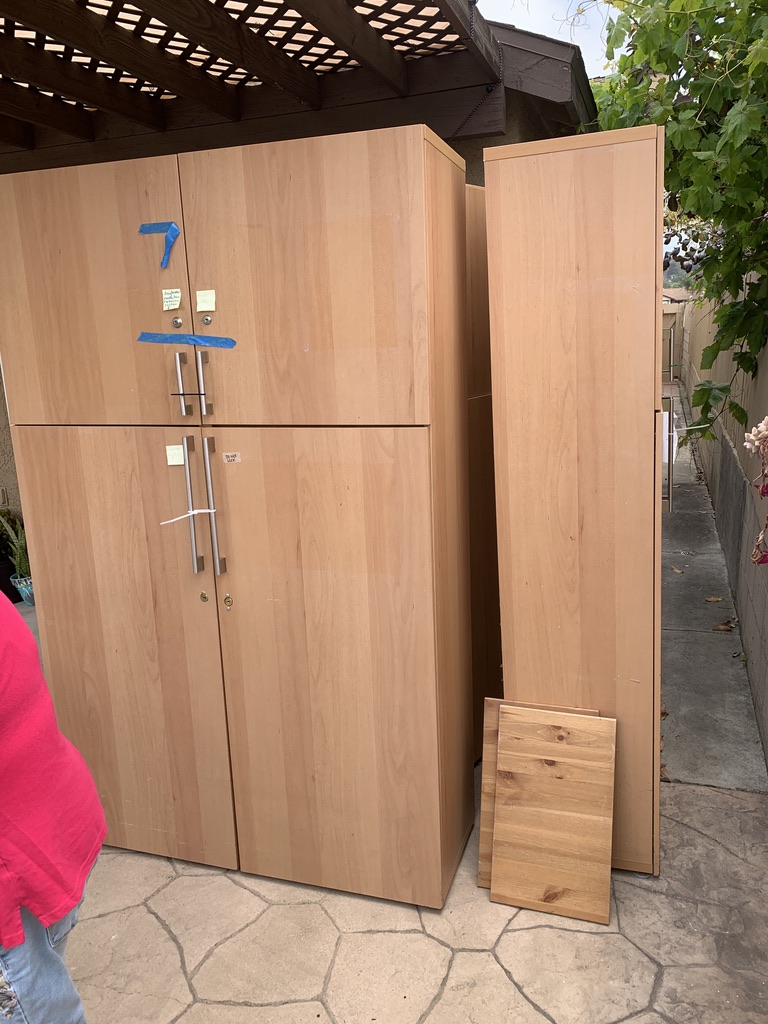 Tall light-wood cabinets staged on a patio for bulky item removal